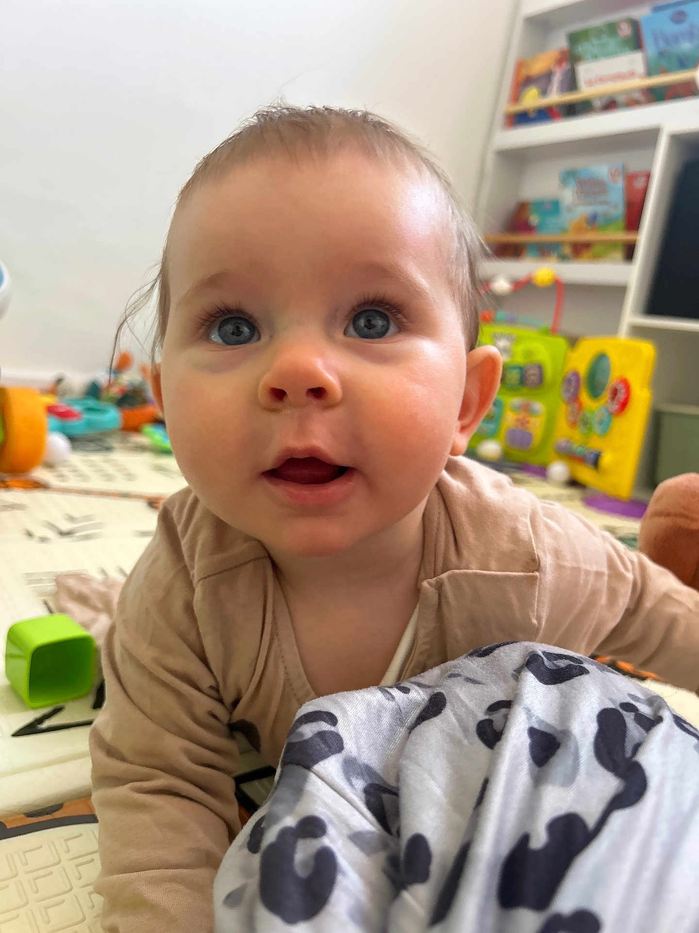 Joy a rejoint le concours — aidez-le/la à gagner de superbes lots ! baby, child, blue_eyes, crawling, play_mat, toys, bookshelf, blanket, indoor, soft_lighting, curious, face, person, clothing, floor, room, furniture, expression, head, skin