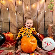 Joy participe au concours pour gagner de l'argent avec cette photo : baby, child, pumpkin, halloween, balloon, orange, black, costume, smiling, string_lights, wooden_background, decorations, festive, holiday, sitting, cute, happy, indoors, holiday_theme, celebration