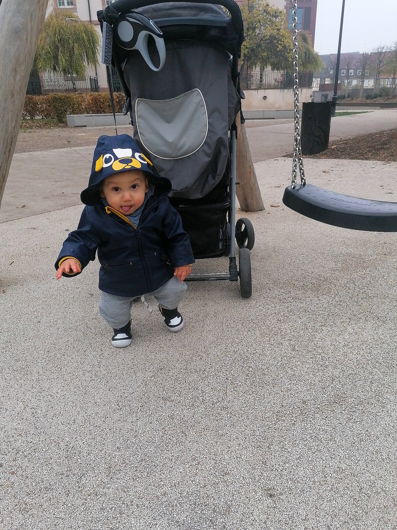 Alex a rejoint le concours — aidez-le/la à gagner de superbes lots ! asphalt, automotive_tire, baby, baby_carriage, baby_toddler_clothing, boot, comfort, fun, grass, headwear, leg, person, recreation, road_surface, rolling, sidewalk, sitting, sneakers, surprise, tire