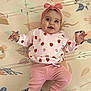 baby, child, smiling, pink_clothing, headband, strawberry_pattern, lying_down, playmat, animal_print, cute, happy, infant, toddler, indoor, apparel, expression, portrait, baby_girl, clothing, hand_gesture