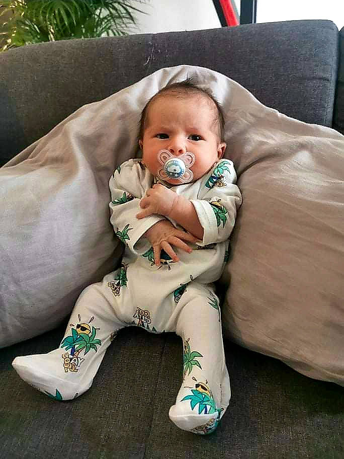 Tiyam participe au concours pour gagner de l'argent avec cette photo : arm, baby, baby_products, baby_toddler_clothing, cheek, comfort, couch, eye, foot, furniture, grass, happy, human_body, iris, linens, person, sitting, skin, sleeve, toddler