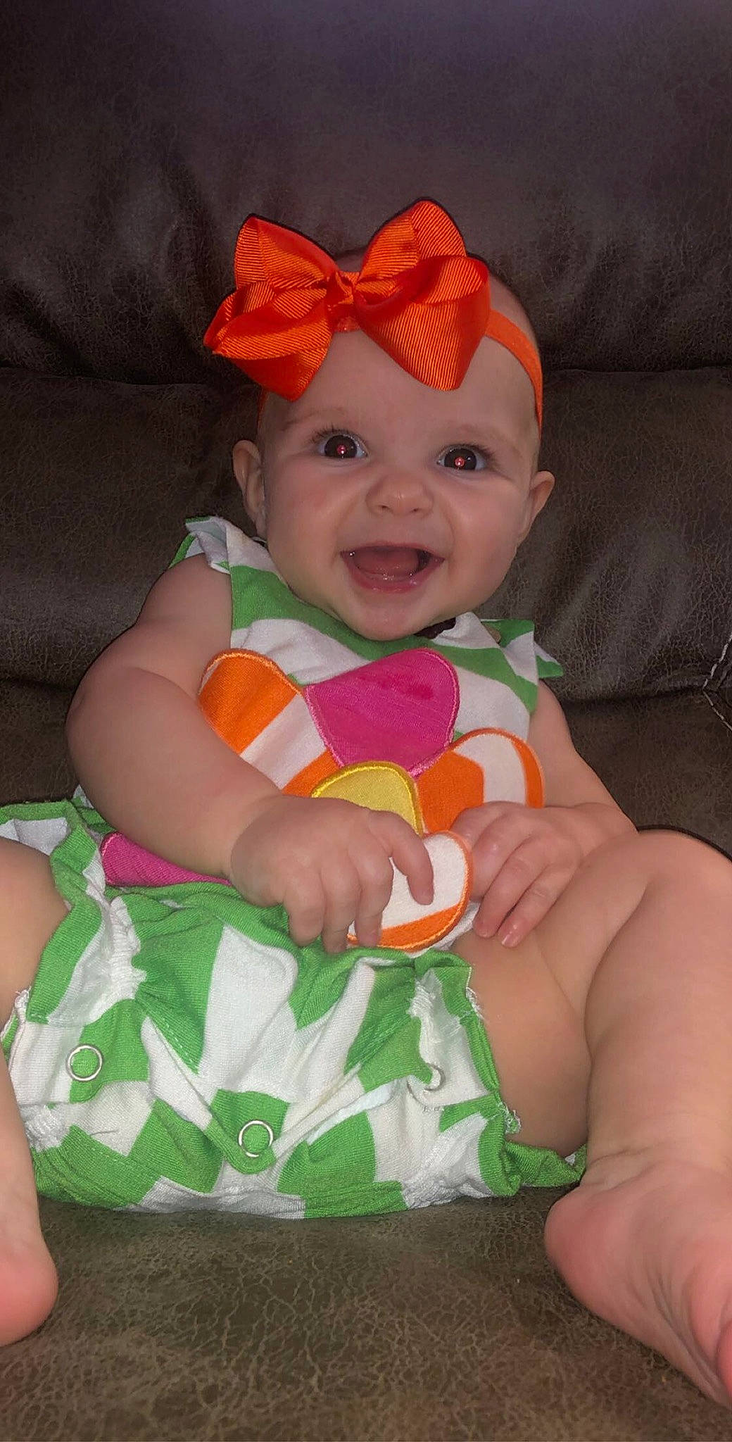 Harper is registered to the contest to win money with this photo: baby, baby_products, baby_toddler_clothing, cap, cheek, child, costume_hat, face, finger, fun, happy, head, headgear, headwear, lap, person, pink, sitting, skin, sleeve