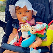 Hailey a rejoint le concours — aidez-le/la à gagner de superbes lots ! baby, baby_clothing, blue_eyes, cat_toy, child, cute, daylight, giraffe_toy, hat, infant, outdoor, pacifier, person, plush_toy, relaxing, seatbelt, smiling, soft_toys, stroller, sun_hat