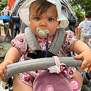 Hailey a rejoint le concours — aidez-le/la à gagner de superbes lots ! baby, child, clothing, cute, face, greenery, hand, hat, infant, nature, outdoor, pacifier, people, person, plush_toy, seatbelt, stroller, summer, sunlight, toy