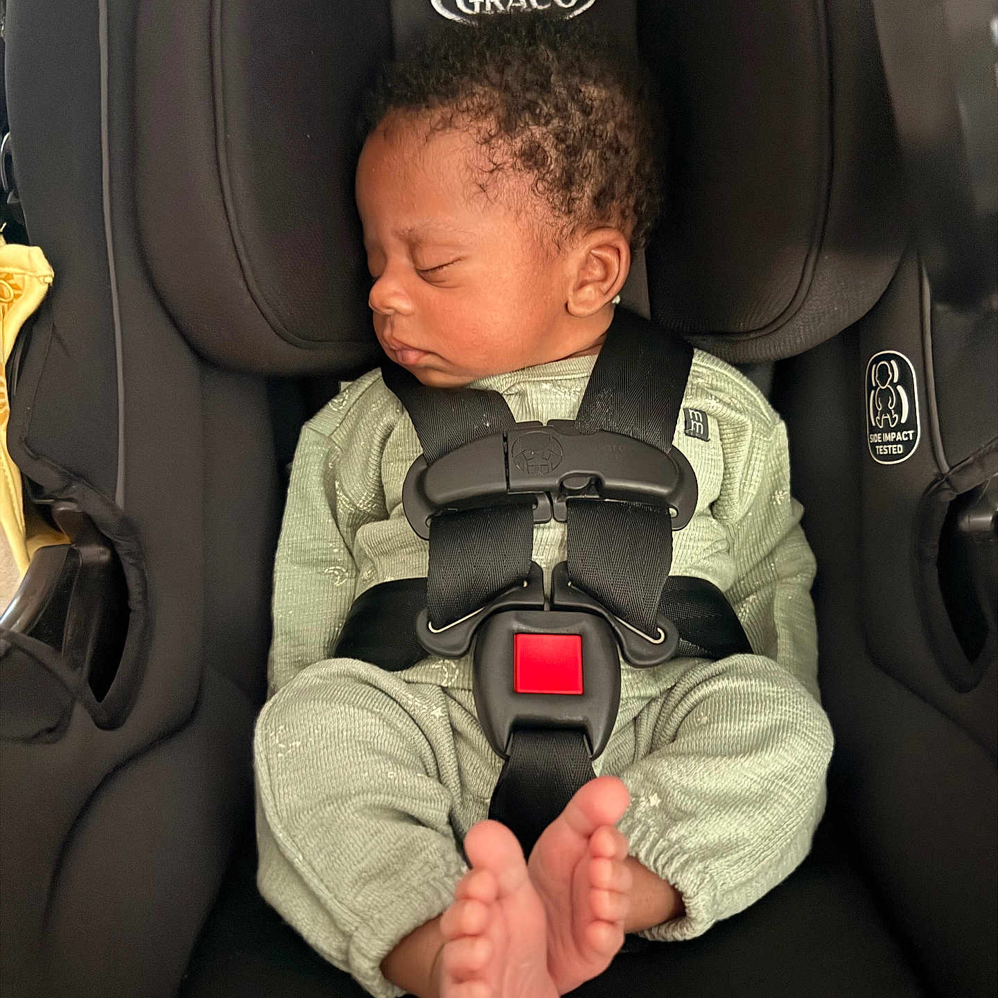 Nikolai is registered to the contest to win money with this photo: newborn, baby, sleeping, infant, car_seat, harness, safety_belt, child, portrait, indoor, vehicle, seated, curly_hair, closed_eyes, green_outfit, bare_feet, peaceful,  안전, photography, graco