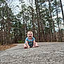 baby, child, infant, sitting, pavement, path, forest, pine_trees, trees, outdoors, nature, smile, happy, striped_clothing, bare_feet, portrait, ground_texture, sky, woodland, young_child