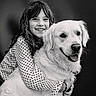 affection, animal, black_and_white, child, close_up, cute, dog, face, friendship, golden_retriever, happy, hugging, indoor, long_hair, pet, polka_dot, portrait, smiling, studio, warmth