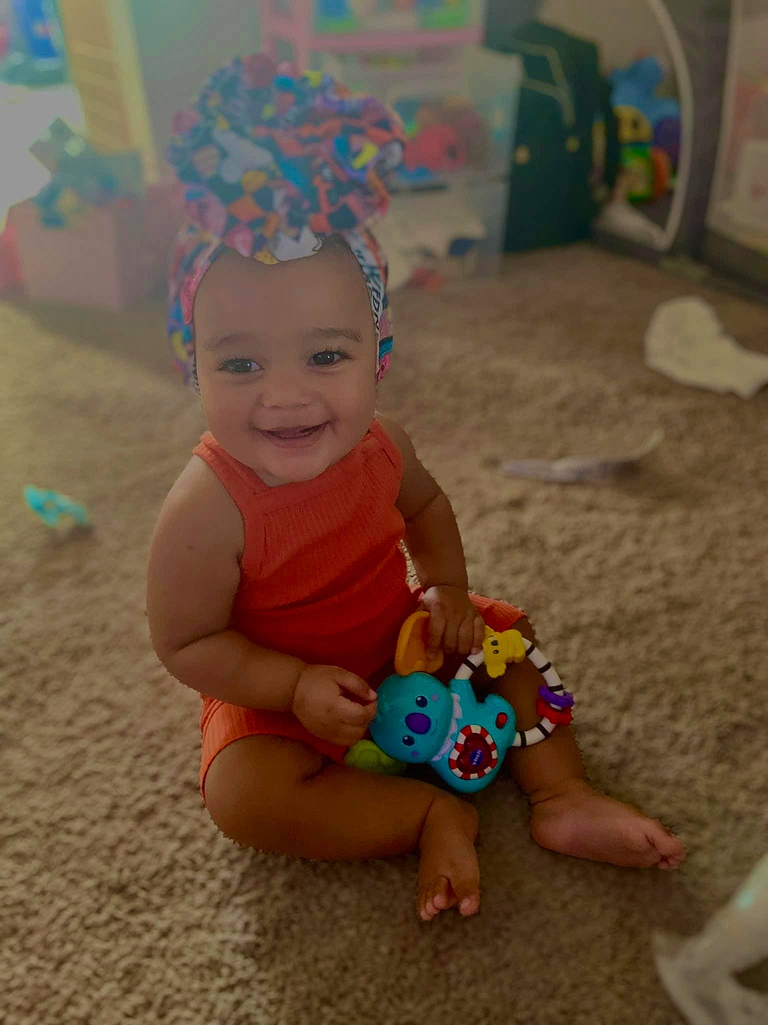 Tru is registered to the contest to win money with this photo: baby, baby_playing_with_toys, baby_toddler_clothing, baby_toys, child, event, facial_expression, flooring, foot, fun, happy, hat, joy, leisure, party_supply, person, play, sand, sitting, smile