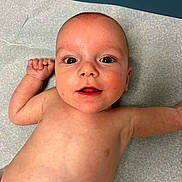 Grayson joined the competition — help win amazing prizes! baby, infant, child, skin, face, eyes, mouth, arm, torso, medical_table, blue_background, newborn, cute, human, expression, lying_down, bare_chest, indoors, healthy, young