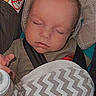 baby, blanket, car_seat, child, closeup, clothing, face, hand, head, indoors, infant, pattern, peaceful, portrait, seatbelt, sleeping, soft_lighting, timestamp, vintage_style, zigzag