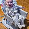 baby, baby_seat, child, childcare, comfort, cute, face, happy, home, indoor, infancy, infant, pajamas, person, playful, seat_belt, sitting, smiling, toy, wooden_floor