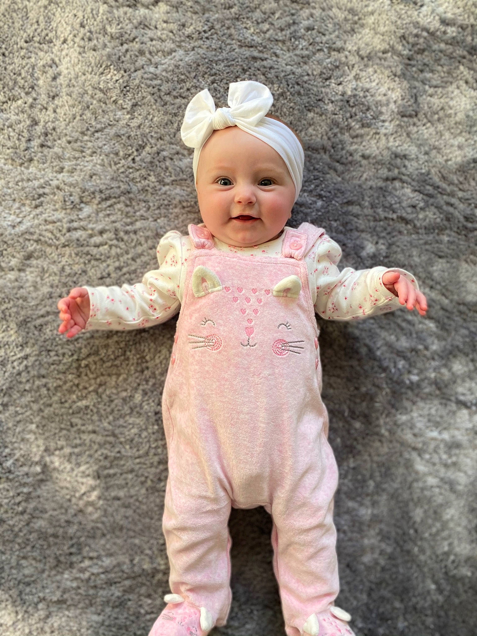 Esmée is registered to the contest to win money with this photo: baby, baby_toddler_clothing, cheek, child, costume, face, fashion_accessory, flooring, fun, gesture, happy, head, headwear, nose, outerwear, people_in_nature, person, pink, skin, sleeve