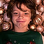 child, boy, freckles, smiling, green_shirt, minecraft, tnt_block, creeper, christmas_ornaments, golden_balls, holiday, festive, lying_down, happy, face, portrait, indoors, decorations, young, casual_clothing