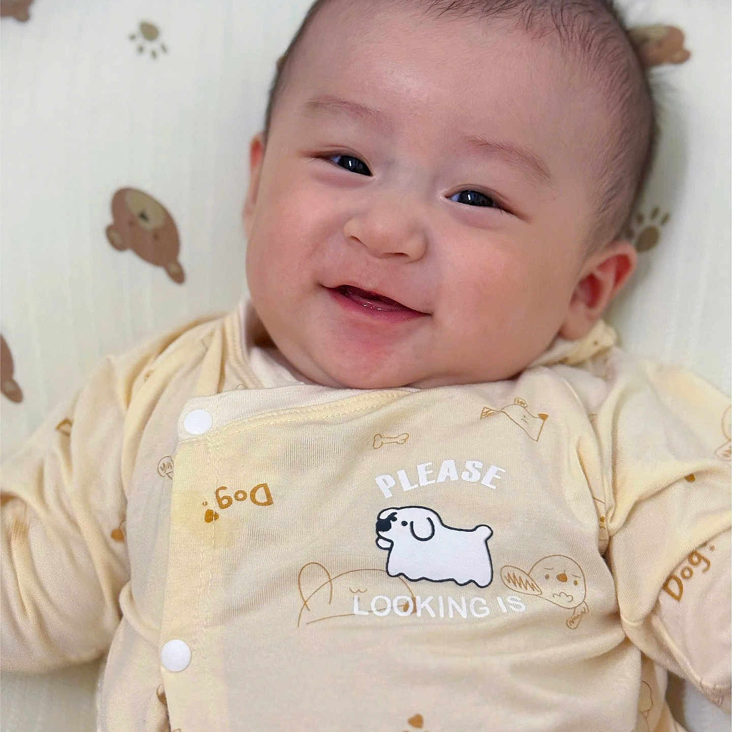 Khang is registered to the contest to win money with this photo: animal_print, baby, child, clothing, comfort, cushion, cute, fabric, face, happy, indoors, infant, light_skin, onesie, pattern, person, portrait, short_hair, smiling, soft_toys