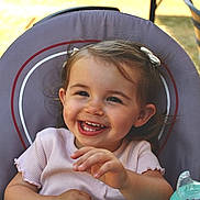 Albane participe au concours pour gagner de l'argent avec cette photo : toddler, child, smiling, happy, baby_bottle, chair, hair_clip, outdoor, daylight, clothing, person, face, cute, young_child, sitting, playful, joyful, skin, hand, casual