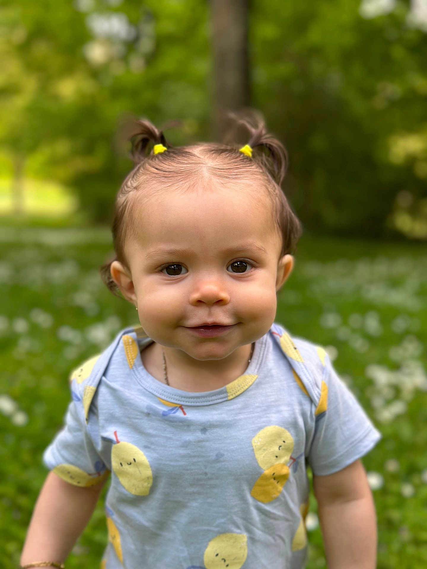 Gëovanna a rejoint le concours — aidez-le/la à gagner de superbes lots ! toddler, child, smiling, outdoor, greenery, grass, flowers, hair_ties, blue_shirt, fruit_pattern, young_child, cute, portrait, nature, happy, person, sunlight, casual_clothing, daylight, baby