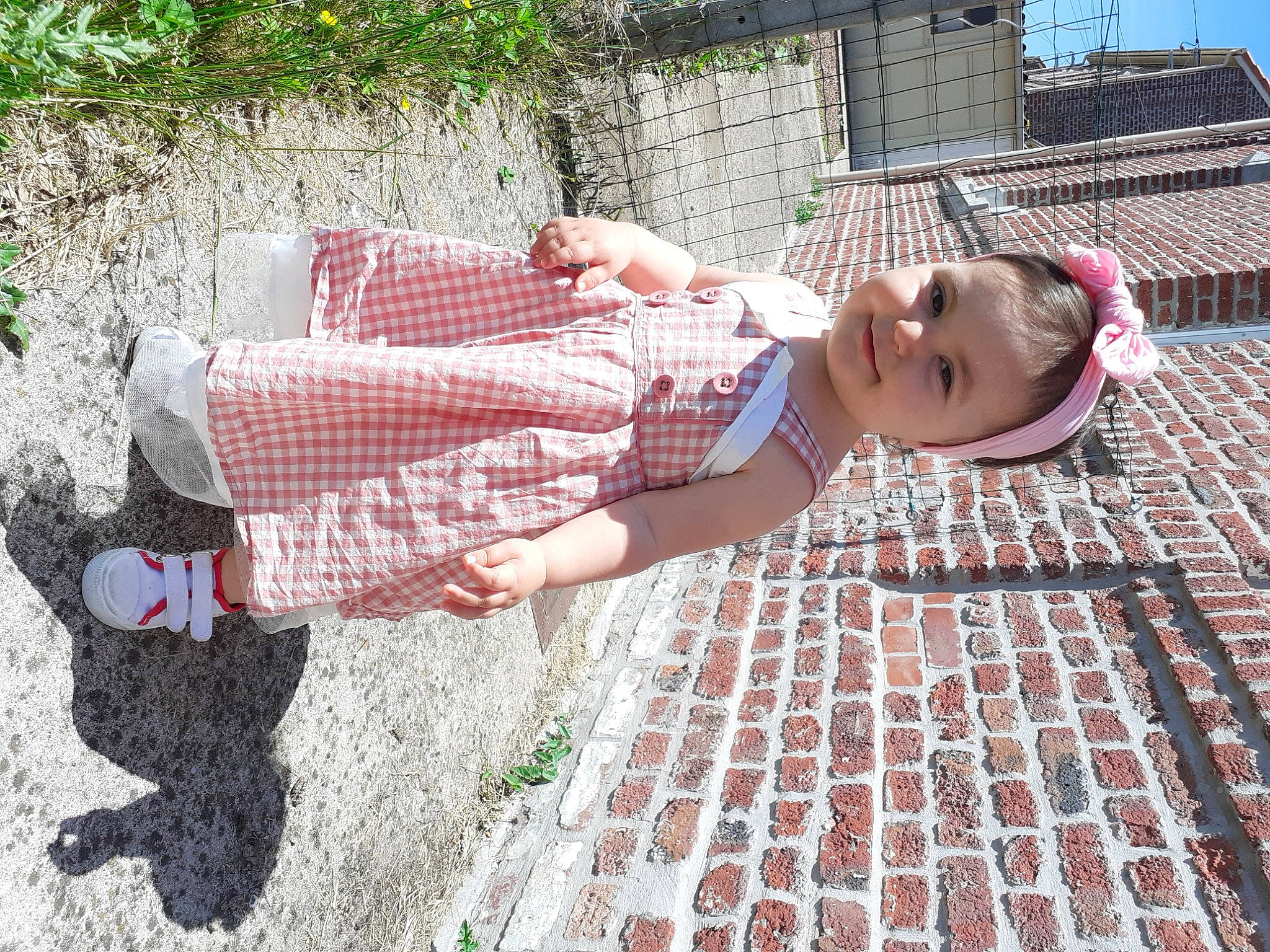 Aïko a rejoint le concours — aidez-le/la à gagner de superbes lots ! brick, child, composite_material, fun, grass, human_leg, joy, leg, leisure, pattern, people_in_nature, person, pink, plant, sidewalk, sitting, smile, street_fashion, summer, textile