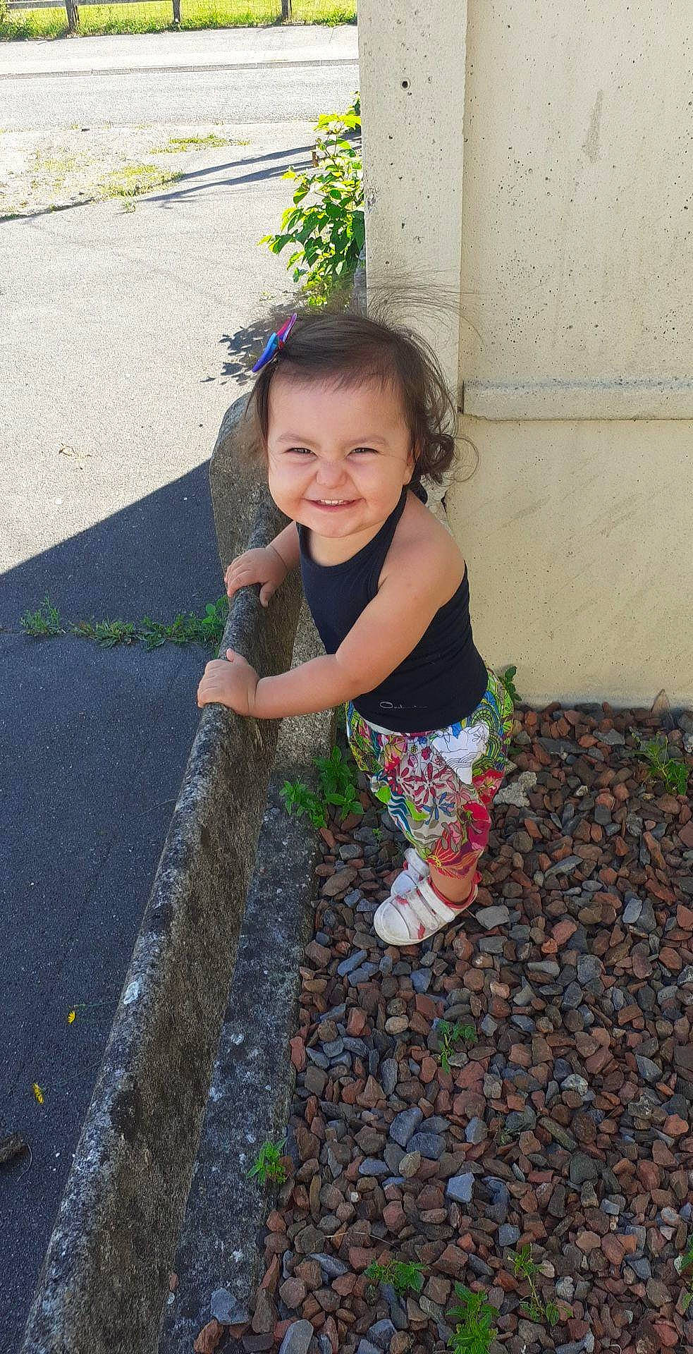 Aïko a rejoint le concours — aidez-le/la à gagner de superbes lots ! asphalt, baby_toddler_clothing, child, fun, grass, happy, human_body, human_leg, joy, leisure, mammal, people_in_nature, person, plant, road_surface, sidewalk, smile, tints_and_shades, toddler, tree