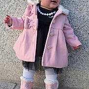 Aitana Sánchez joined the competition — help win amazing prizes! toddler, child, hat, pom_pom, pink_coat, bows, boots, outdoor, stone_wall, white_tights, black_dress, smiling, standing, winter_clothing, curious, portrait, footwear, baby, fashion, warm