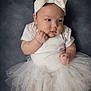 baby, infant, tutu, headband, bow, white_clothing, cute, portrait, chubby_cheeks, soft_lighting, studio_background, small_hands, barefoot, sitting, closeup, adorable, child, fashion, tulle, expression