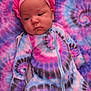 baby, infant, sleepwear, tie_dye, pink, blue, blanket, headwear, bonnet, clothing, face, person, cute, newborn, portrait, soft, resting, child, pattern, fabric