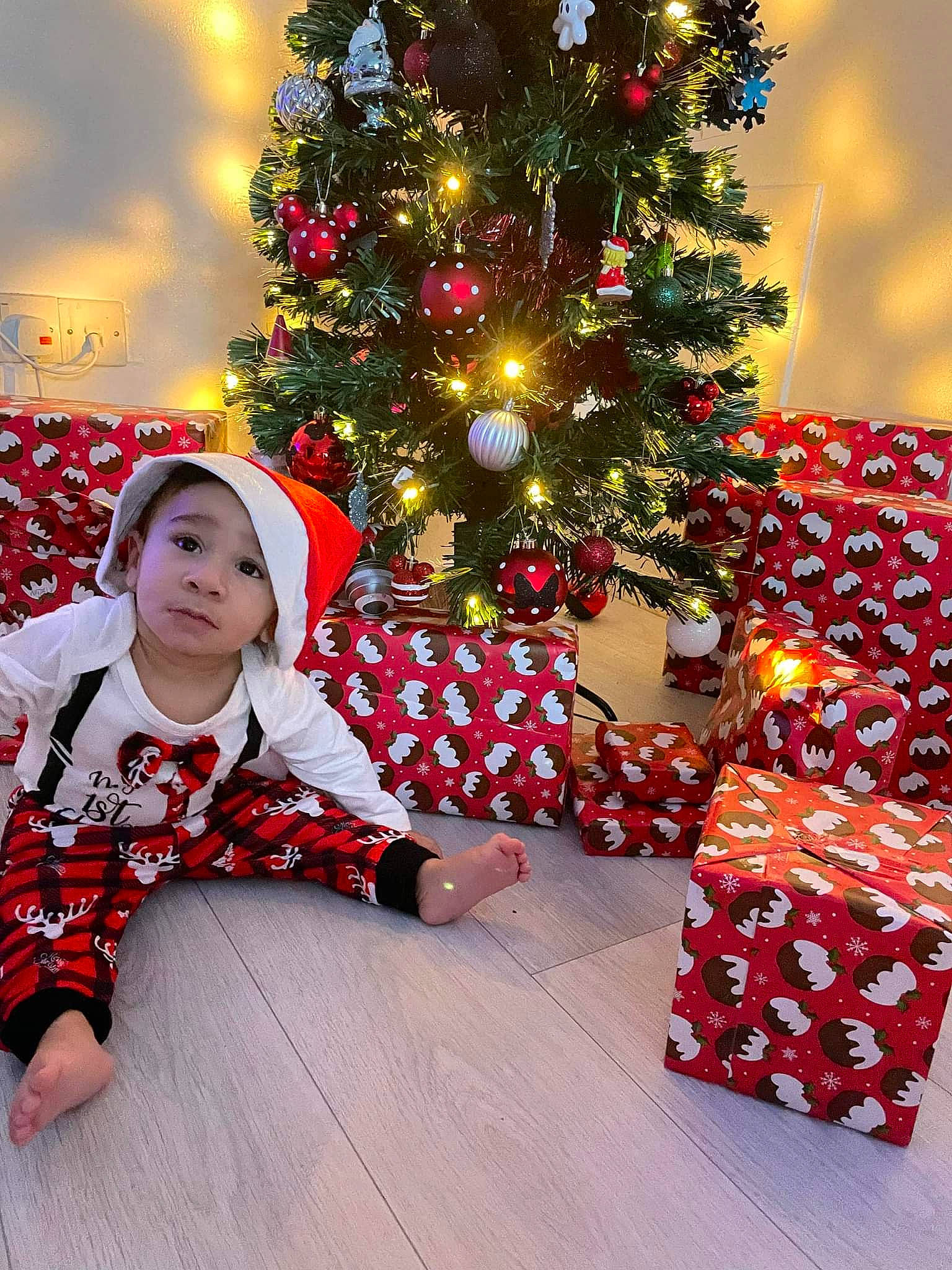 Jake is registered to the contest to win money with this photo: baby_toddler_clothing, christmas, christmas_decoration, christmas_eve, christmas_ornament, christmas_tree, event, evergreen, fun, happy, headwear, holiday, holiday_ornament, ornament, pattern, person, plant, red, sleeve, toddler