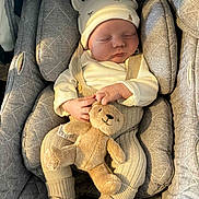 Riley is registered to the contest to win money with this photo: baby, sleeping, infant, teddy_bear, plush_toy, car_seat, knitwear, hat, cozy, child, cute, peaceful, soft_lighting, indoors, cushion, comfort, resting, small_child, adorable, portrait