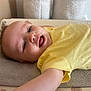 baby, child, yellow_shirt, smiling, face, towel, arm, lying_down, indoor, skin, head, mouth_open, happy, expression, person, cute, infant, young, portrait, baby_clothes