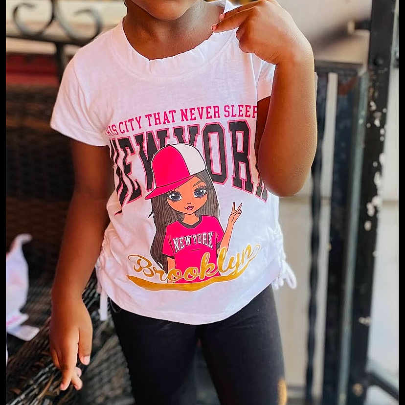 Jevi joined the competition — help win amazing prizes! braids, casual_clothing, child, crocs, curious, expression, fashion, girl, leggings, new_york, outdoor, pink_beads, pointing, porch, portrait, standing, tshirt, wicker_chair, wood_floor, young_child