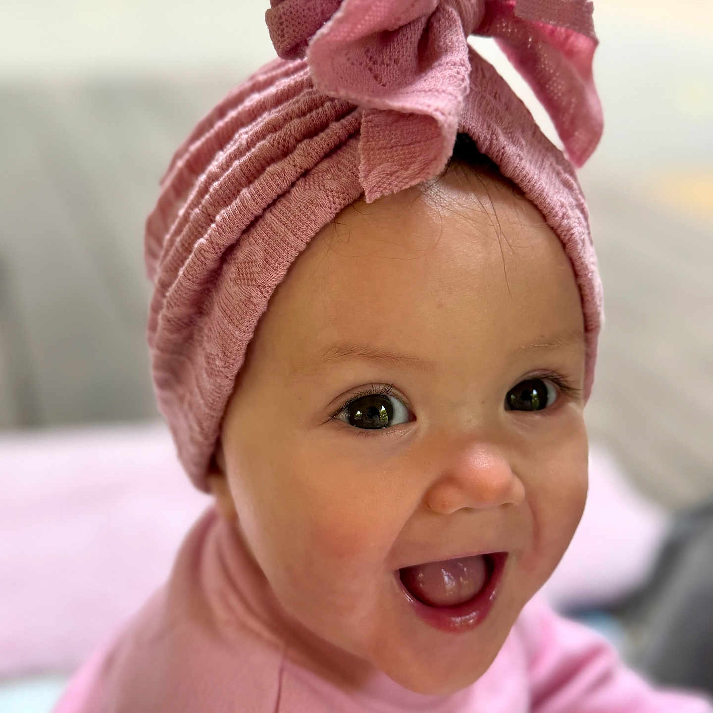 Rebecca is registered to the contest to win money with this photo: baby, cheeks, child, closeup, clothing, cute, expressive_eyes, face, happy, headwear, headwrap, indoors, infant, mouth_open, pink_clothing, portrait, skin, smiling, soft_light, young_child