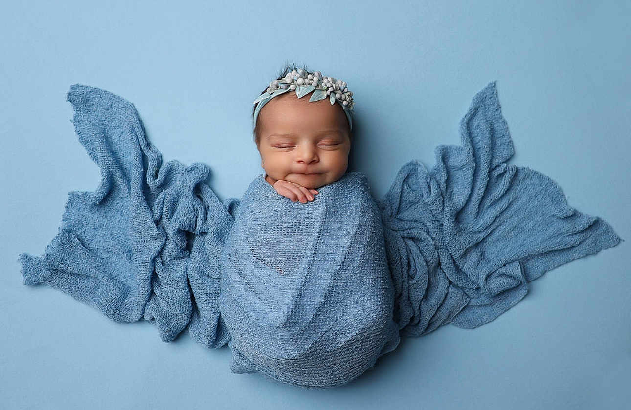 Maribelle is registered to the contest to win money with this photo: newborn, baby, infant, wrapped, blue_blanket, headband, sleeping, peaceful, portrait, studio, soft_texture, fabric, cute, angelic, child, sweet, background, closeup, smile, resting