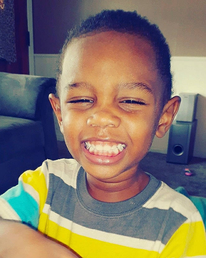 Kyron is registered to the contest to win money with this photo: baby_toddler_clothing, black_hair, cheek, child, cool, couch, ear, eye, eyebrow, forehead, hairstyle, happy, head, jaw, joy, lip, mouth, nose, person, pleased