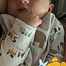 baby, infant, sleeping, sleepy, portrait, close_up, face, hand, fist, onesie, clothing, indoor, warm_lighting, winnie_the_pooh, cartoon, plush_character, cuddly, peaceful, parent, cozy