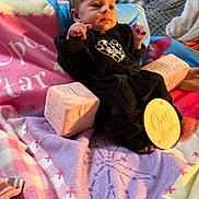 Anora joined the competition — help win amazing prizes! baby, infant, one_month, plush_block, wooden_sign, blanket, pastel_colors, black_outfit, leopard_print, heart_patch, bedroom, pillow, soft_toys, newborn, portrait, sitting, cute, child, warm_lighting, indoors