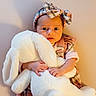 baby, bow, bunny, child, clothing, cute, dress, expression, headband, indoors, infant, plaid, plush_toy, portrait, shadow, sitting, soft_lighting, stuffed_animal, wall, young