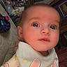 Anora is registered to the contest to win money with this photo: baby, infant, child, face, eyes, bib, clothing, indoor, portrait, cute, expression, toy, stuffed_animal, furniture, home, person, young_child, curious, closeup, casual