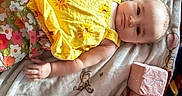 Anora is registered to the contest to win money with this photo: baby, baby_clothes, baby_face, baby_hand, balloons, blanket, blocks, child, cute, five_months, floral_pants, indoors, infant, lying_down, milestone, portrait, smiling, soft_toys, teddy_bear_pattern, yellow_top