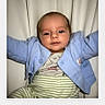 arms, baby, blue_jacket, child, closeup, clothing, curious, cute, expression, face, head, indoor, infant, person, portrait, sitting, smile, soft_lighting, striped_pants, young