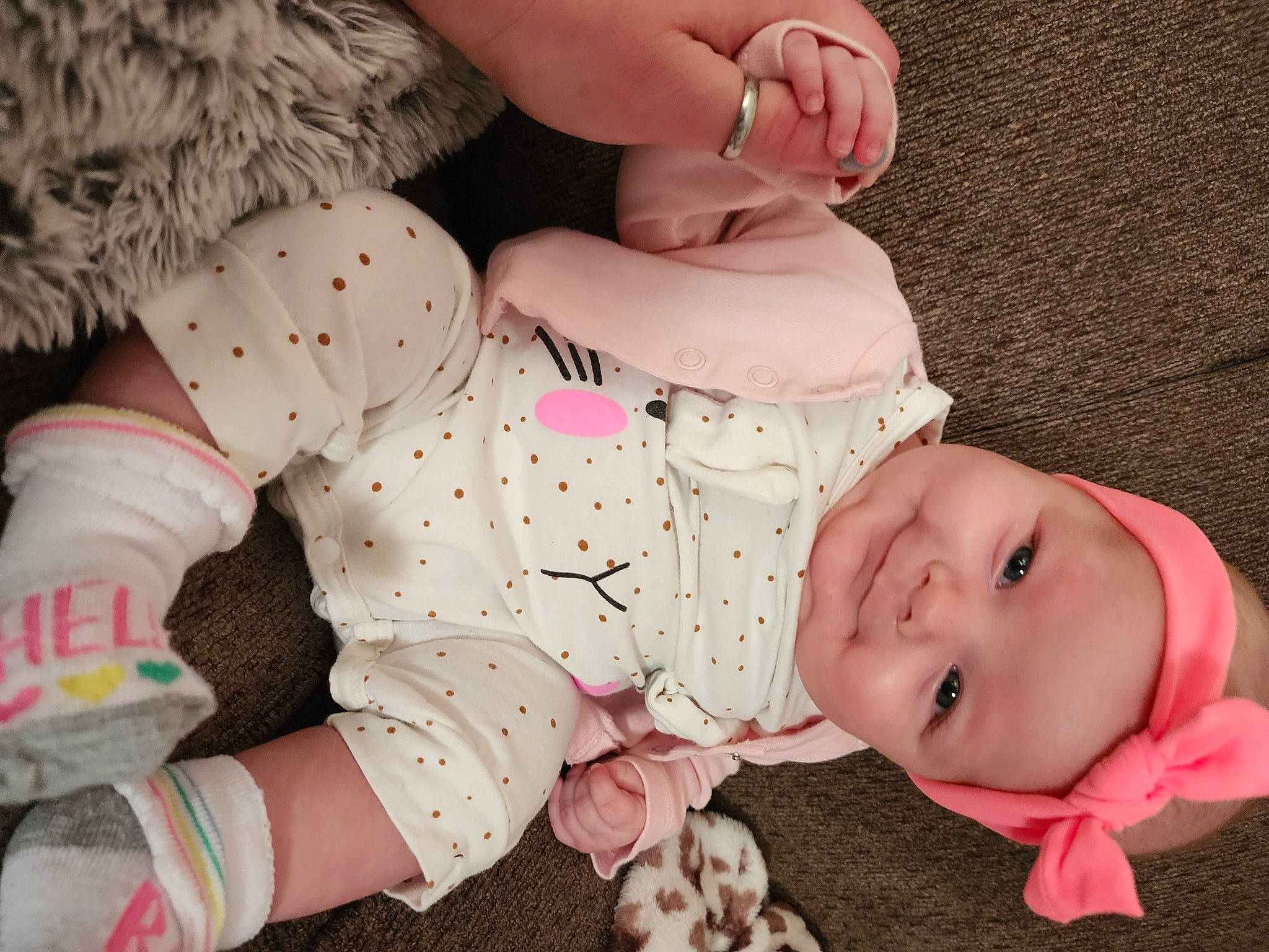 Joslyn is registered to the contest to win money with this photo: arm, baby, baby_toddler_clothing, comfort, finger, foot, happy, headwear, human_body, human_leg, joy, knee, leg, pattern, person, pink, skin, sleeve, textile, thigh