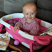 Patsy joined the competition — help win amazing prizes! baby, child, pink_sweater, toy_bathtub, colorful_balls, blanket, floor, smiling, indoor, cozy, plastic, playing, cute, toddler, childhood, furniture, couch, wood_floor, happy, person