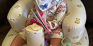 Patsy joined the competition — help win amazing prizes! baby, barefoot, bib, child, cute, floral_outfit, happy, indoor, infant, inflatable_chair, person, pink_toy, portrait, purple_toy, seated, smiling, soft_book, teddy_bear_pattern, toy, wood_floor