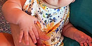 Patsy joined the competition — help win amazing prizes! adult_hand, baby, blue_eyes, child, comfort, couch, curious_expression, floral_pattern, hand, headband, indoor, infant, lap, onesie, person, pink, sitting, skin, white, yellow