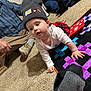 Patsy is registered to the contest to win money with this photo: adult, baby, carpet, casual_clothing, child, colorful, crawling, curious, family, floor, hat, indoor, knit_hat, long_sleeve, patch, people, plaid_skirt, quilt, sitting, toy