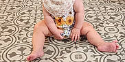 Patsy is registered to the contest to win money with this photo: baby, barefoot, bow, child, clothing, cute, expression, face, floor, happy, headband, indoors, infant, legs, pattern, person, playful, sitting, smile, tile