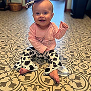 Patsy joined the competition — help win amazing prizes! baby, child, smiling, sitting, indoor, floor, patterned_floor, headband, bow, clothing, pants, long_sleeve, pink_shirt, cow_print, happy, cute, person, infant, toes, eyes