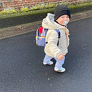Alejandro participe au concours pour gagner de l'argent avec cette photo : backpack, beanie, brick_wall, casual, child, cute, daytime, footwear, jacket, outdoor, pacifier, pavement, person, side_view, smiling, toddler, urban, walking, winter_clothing, young