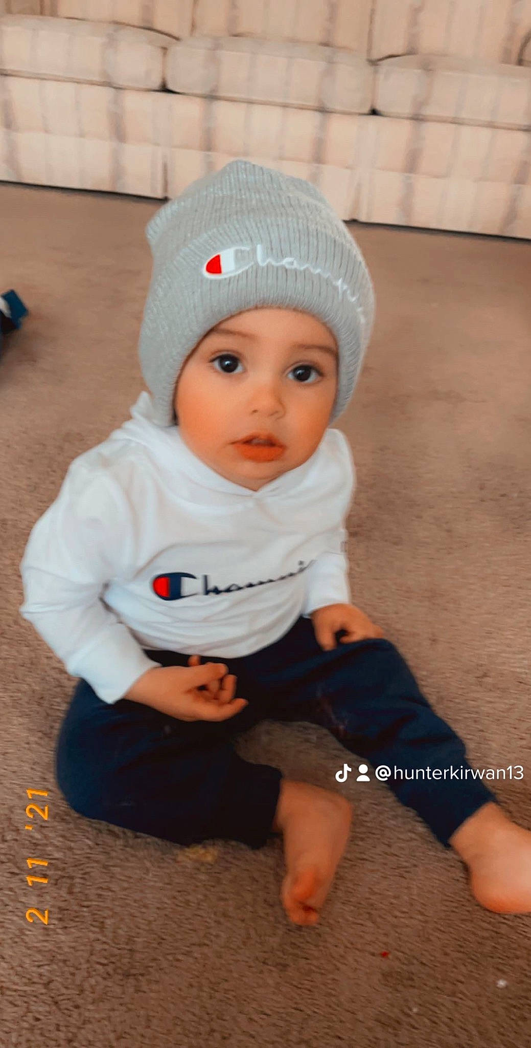 Marcus joined the competition — help win amazing prizes! baby, baby_toddler_clothing, beanie, cap, cheek, child, costume_hat, face, fashion_accessory, flooring, fun, happy, headgear, headwear, knit_cap, pattern, person, sitting, sleeve, surprise