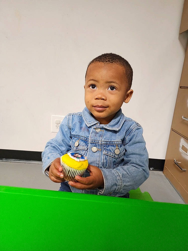 Zion is registered to the contest to win money with this photo: arm, baby, baby_toddler_clothing, ball, cabinetry, chest_of_drawers, child, drawer, finger, flooring, football, fun, happy, person, sitting, sleeve, smile, sports_equipment, t_shirt, toddler