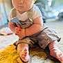 Ventus is registered to the contest to win money with this photo: baby, child, carpet, toy, hammer, indoor, sitting, clothing, foot, hand, face, person, cute, soft_light, blurred_background, infant, home, floor, portrait, play