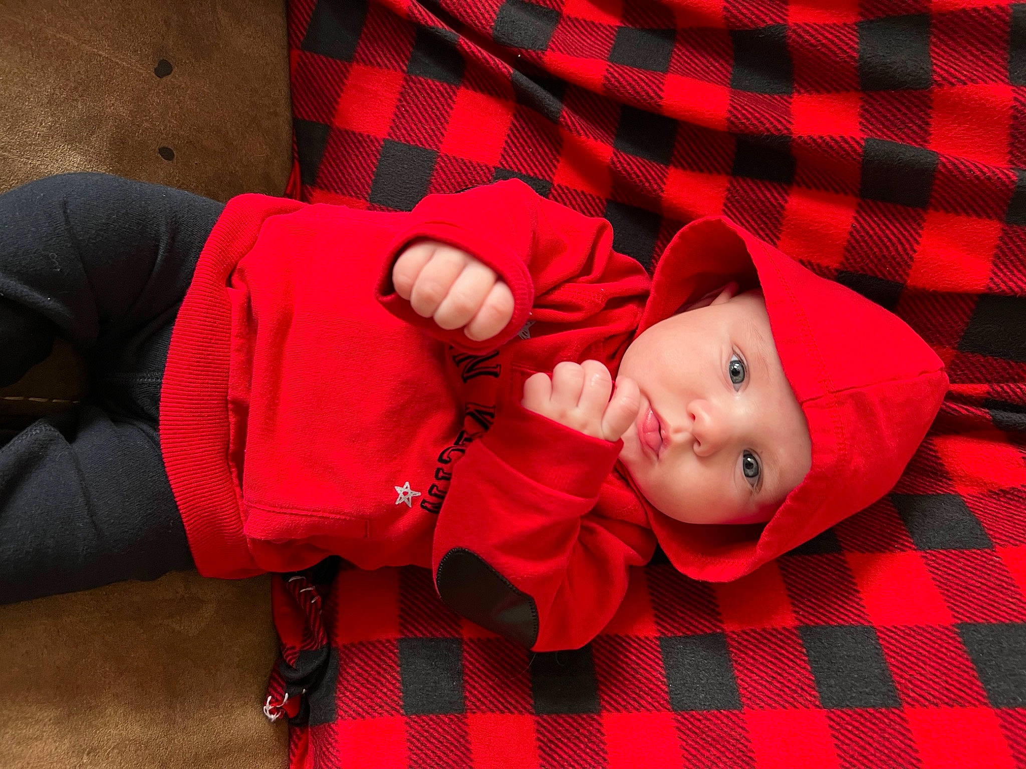 Jonah is registered to the contest to win money with this photo: baby, baby_toddler_clothing, carmine, child, collar, comfort, grass, headwear, human_leg, knee, linens, magenta, pattern, person, plaid, red, sitting, sleeve, tartan, textile